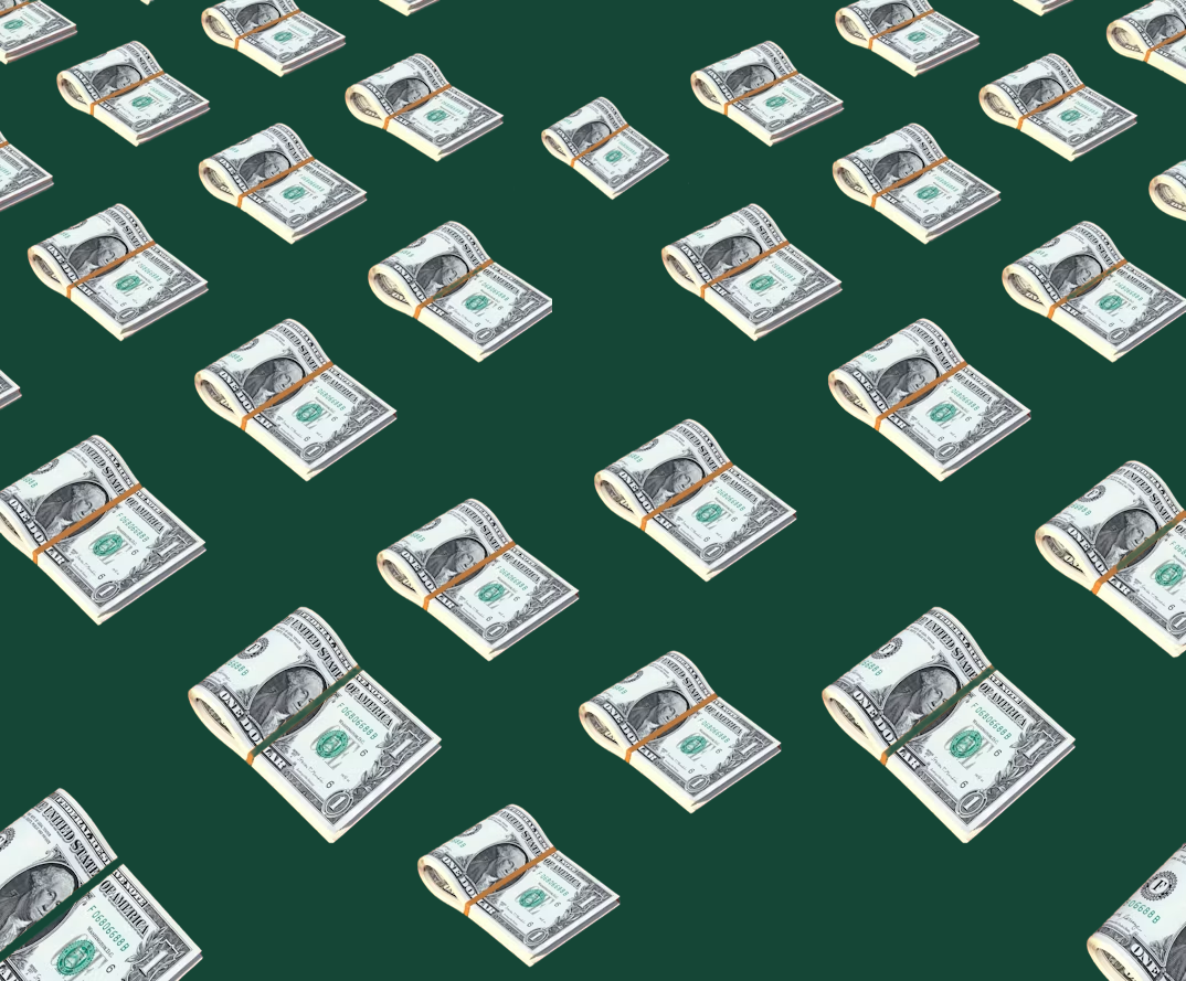 Stacks of dollar bills laid out in a grid on a deep green background